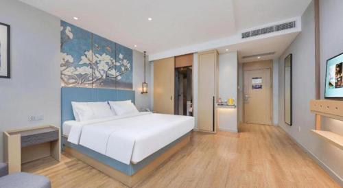 a bedroom with a large white bed in a room at Magnotel Hotel Xiamen North Station Binhai in Xiamen