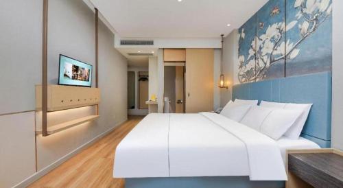 a large white bed in a large room at Magnotel Hotel Xiamen North Station Binhai in Xiamen