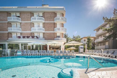 a swimming pool in front of a hotel at Hotel San Francisco in Lignano Sabbiadoro
