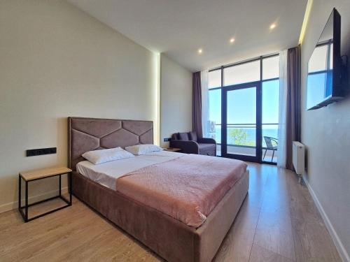 una camera da letto con un letto grande e una grande finestra di Сучасна квартира з терасою на морі та підземний паркінг a Odessa