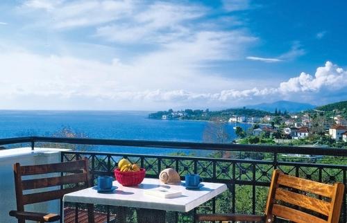 a table with a bowl of fruit on a balcony at Hotel Apartments Sikia in Kato Gatzea