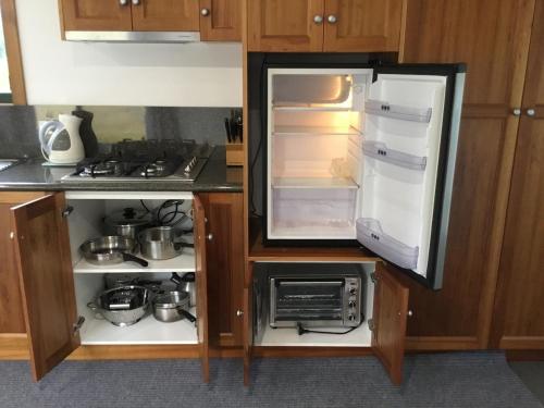 a kitchen with an open refrigerator and a stove at Cabin in the Tasmanian Bush - Tranquility! in Pipers River