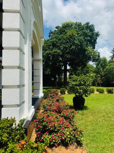 a white house with flowers on the side of it at Stuart House Tangalle in Tangalle