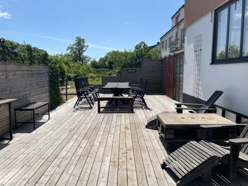 a wooden deck with a picnic table and chairs at Udda boende med wow-känsla in Löderup