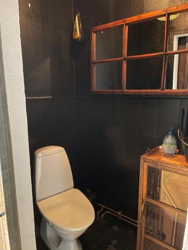 a bathroom with a toilet and a window at Udda boende med wow-känsla in Löderup