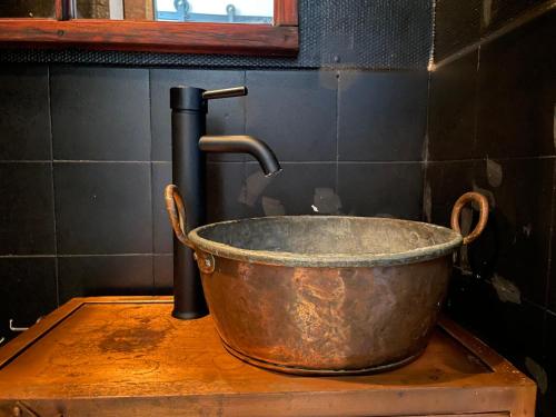a metal bucket on top of a table with a faucet at Udda boende med wow-känsla in Löderup