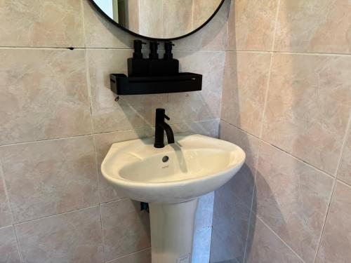 a bathroom with a sink and a mirror on the wall at Khao Sok Jungle Hostel in Khao Sok