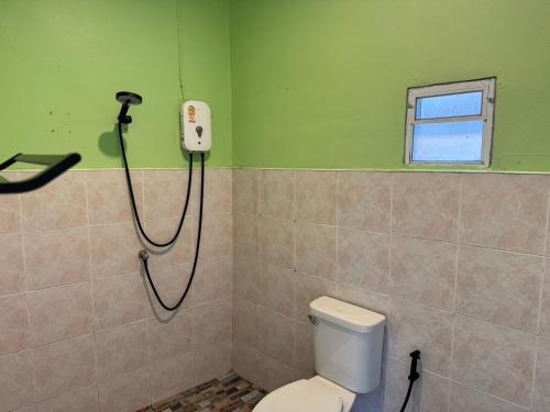 a bathroom with a toilet and a phone on the wall at Khao Sok Jungle Hostel in Khao Sok