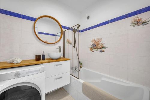 une salle de bain avec une baignoire, un lavabo et un miroir dans l'établissement Bel appartement vue mer proche de la promenade des anglais, à Nice