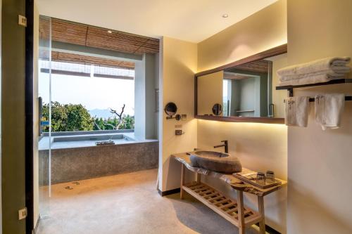 a bathroom with a sink and a mirror at Qingyuan Zhilin Hot Spring Bed and Breakfast in Qingyuan