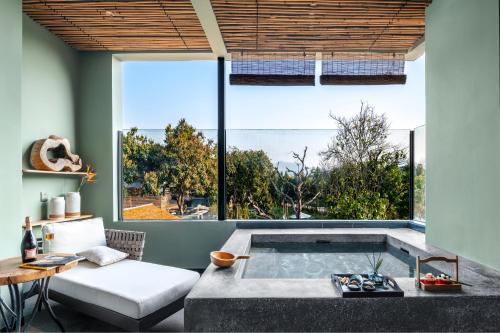 a living room with a jacuzzi tub in front of a window at Qingyuan Zhilin Hot Spring Bed and Breakfast in Qingyuan