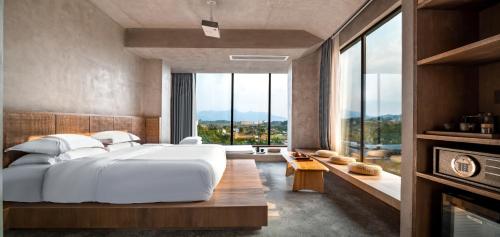 a bedroom with a large white bed and a large window at Qingyuan Zhilin Hot Spring Bed and Breakfast in Qingyuan
