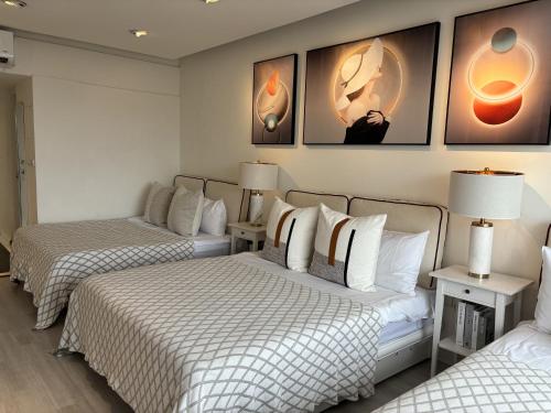 two beds in a room with paintings on the wall at 樂居 台北 in T'ung-ko