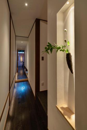 a hallway of a house with a plant on the wall at Hinaya Higashiyama Machiya House in Kanazawa