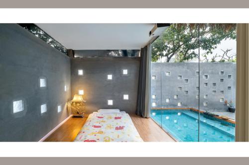 a bedroom with a bed next to a swimming pool at Qingyuan Zhilin Hot Spring Bed and Breakfast in Qingyuan