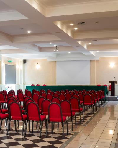a lecture hall with red chairs and a podium at Grand Hotel Terme in Riolo Terme
