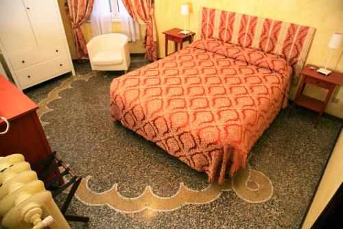 a bedroom with a bed with an orange comforter at Hotel Delle Rose in Rapallo