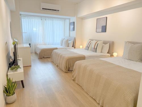 a hotel room with two beds and a television at 樂居 台北 in T'ung-ko