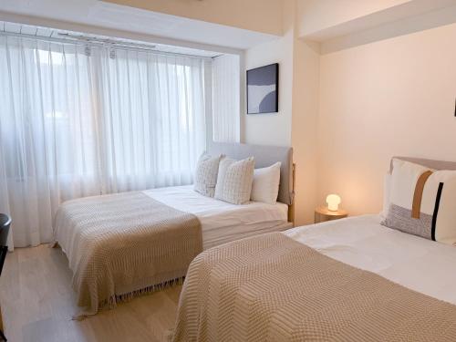 a hotel room with two beds and a couch at 樂居 台北 in T'ung-ko