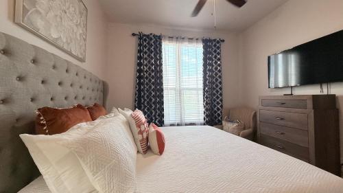 a bedroom with a large white bed with a window at Skyline Stay in Houston