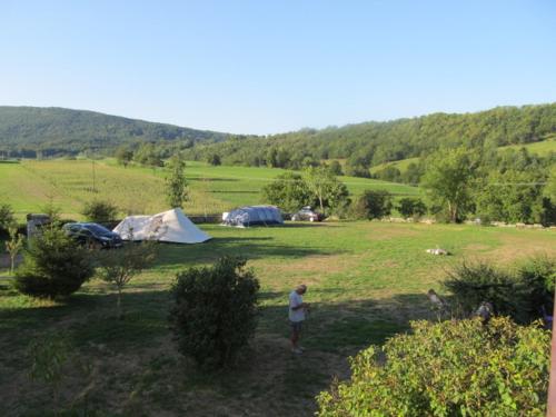 a man standing in front of a field with tents at Goute la vie in Marchamp