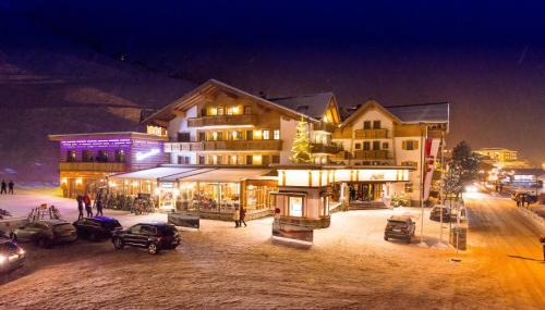 a building with cars parked in front of it at night at Hotel Auhof in Grossarl