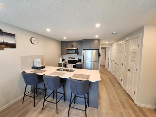 a kitchen with a large island in a room at Cozy & Stylish AC Suite Near YYC Airport in Calgary