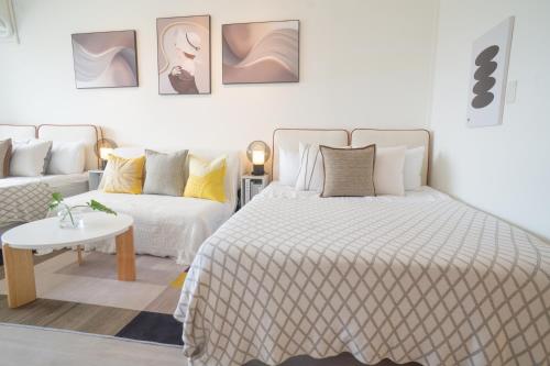 a white bedroom with a bed and a couch at 樂居 台北 in T'ung-ko