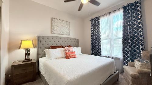 a bedroom with a bed and a lamp and a window at Skyline Stay in Houston