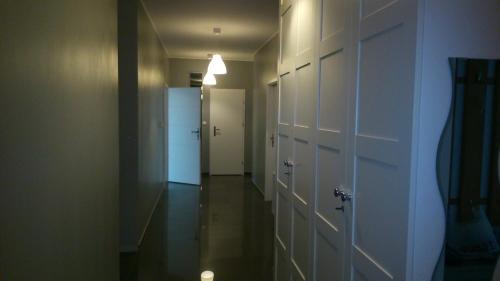 an empty hallway with a white door and a hallway with a guitar at FRESCO Suite & Rooms in Łódź