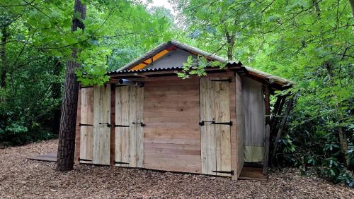 a small wooden shed in the middle of a forest at Glampingtent Bosgenot in Zedelgem