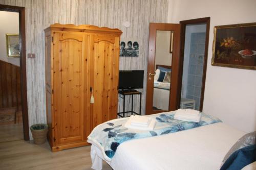 a bedroom with a bed and a wooden cabinet at La Ghita in Sparone