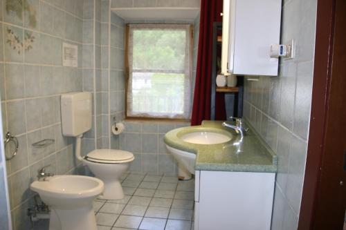 a small bathroom with two toilets and a sink at La Ghita in Sparone