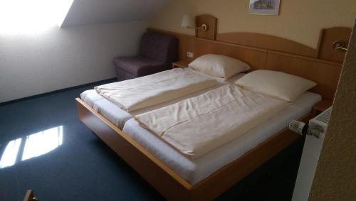 ein Schlafzimmer mit einem großen Bett und einem Stuhl in der Unterkunft Apartmány v Bavorském lese in Mitterfirmiansreut