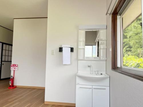 a white bathroom with a sink and a window at 竹の宿 2025年リノベ古民家 最大16名宿泊対応 湖まで徒歩4分 in Fujikawaguchiko