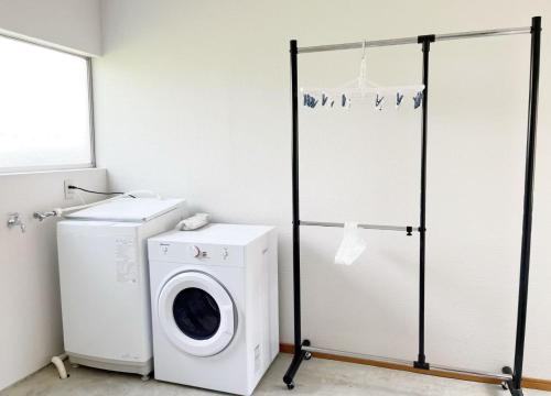 a laundry room with a washing machine and a washer at 竹の宿a 2025年リノベ古民家 最大16名宿泊対応 湖まで徒歩4分 in Fujikawaguchiko