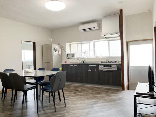 a kitchen and dining room with a table and chairs at 竹の宿a 2025年リノベ古民家 最大16名宿泊対応 湖まで徒歩4分 in Fujikawaguchiko