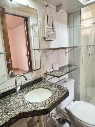 a bathroom with a sink and a toilet and a mirror at Apê 003 in São Luís