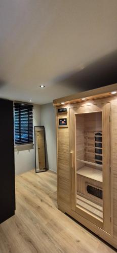 a room with a large wooden cabinet in a room at Veluwse Wellness Lodge Selina in Ermelo