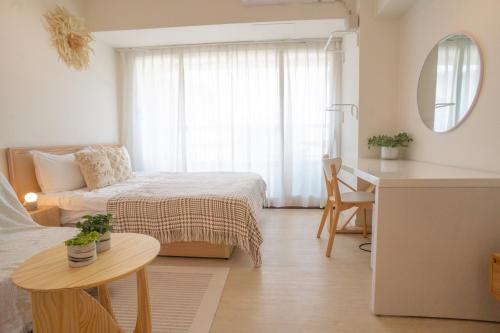 a bedroom with a bed and a desk and a table at 樂居 台北 in T'ung-ko