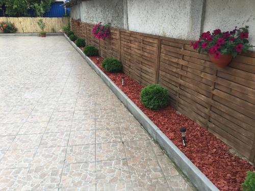 a retaining wall with flowers in a garden at Abszolút Hotel és Panzió in Nyírbátor