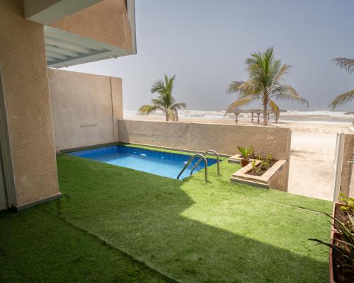 a backyard with a swimming pool and the beach at Luxury Villa Beach Front in Salalah