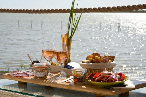 a table with glasses of wine and food on it at Lodge Sainte Helene Adult only in Saintes-Maries-de-la-Mer
