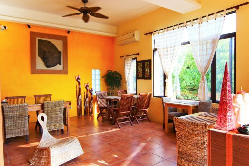a living room with yellow walls and tables and chairs at Ibali Hostel in Magong