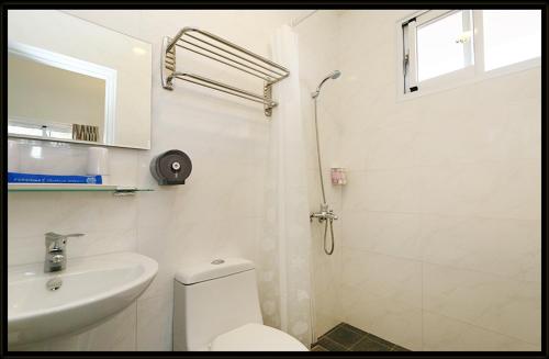 a white bathroom with a toilet and a sink at Bella Casa B&B in Longtian