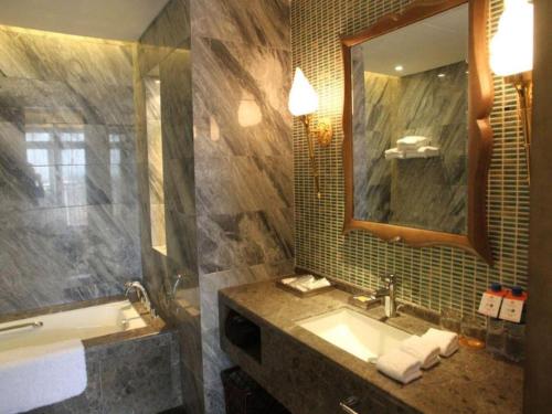 a bathroom with a sink and a mirror at Wuhan Gleetour Hotel in Wuhan
