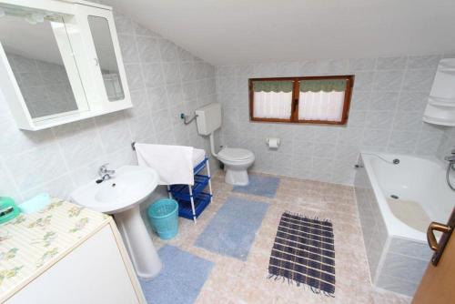 a bathroom with a sink and a toilet and a tub at Apartments Peteh in Rovinj