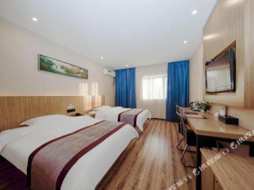 a hotel room with two beds and a desk at GreenTree Alliance Ningbo South Train Station Shunde Road Hotel in Ningbo