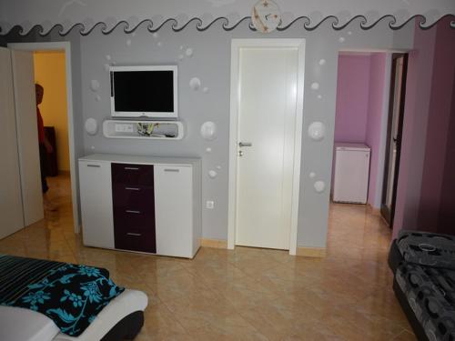 a bedroom with a tv on a wall at Apartmani Niksic in Herceg-Novi
