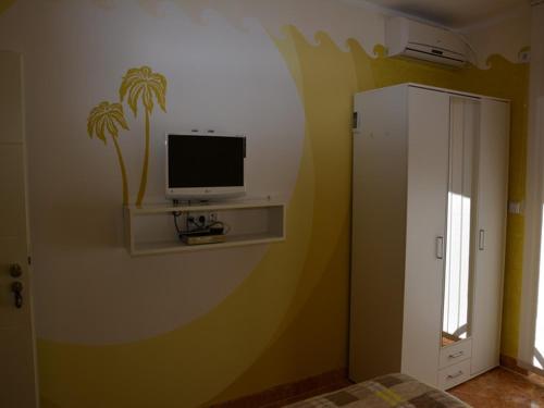 a bedroom with a tv on a wall at Apartmani Niksic in Herceg-Novi